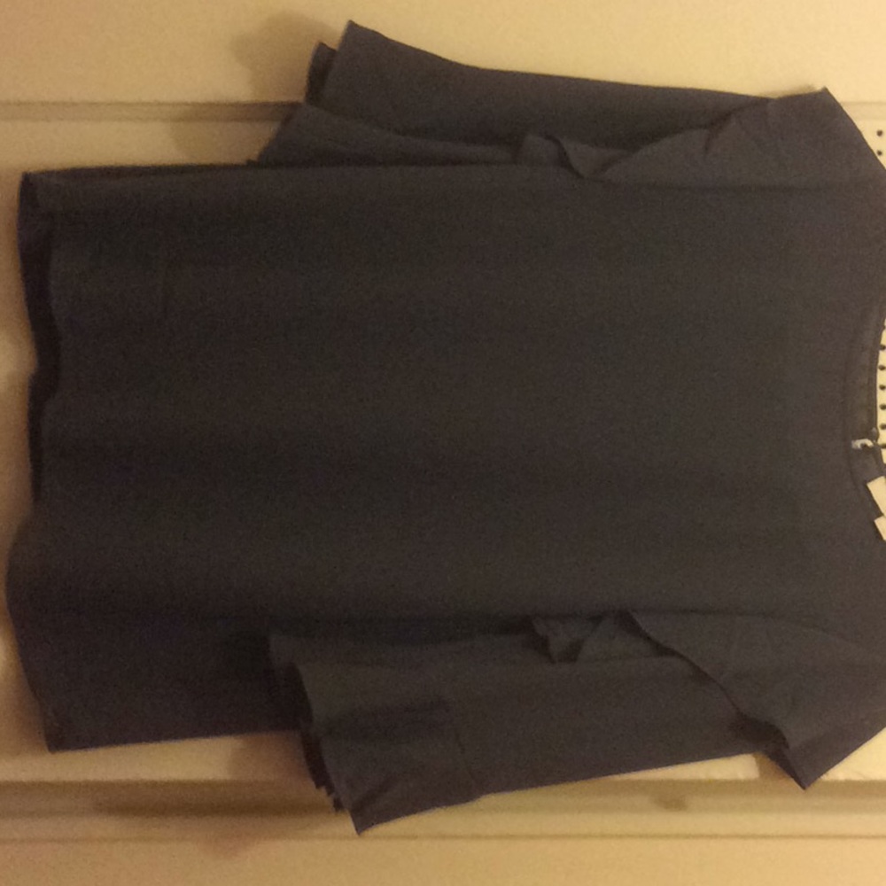 Gray/lavender blouse with ruffle on the/bottom.